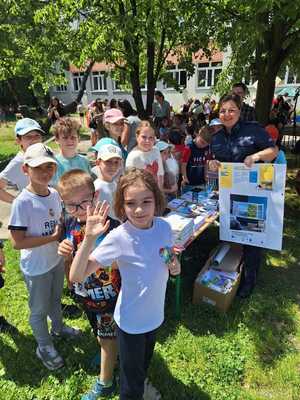 policjantka wraz z uczniami przy stanowisku profilaktycznym