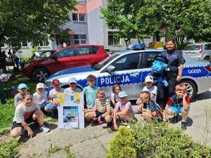policjantka z uczniami przy radiowozie
