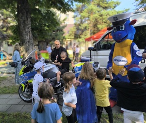 dzieci rozmawiają z policyjną maskotką na festynie