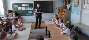 policjantka pokazująca obrazem uczniom