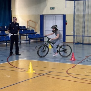 umundurowany policjant nadzorujący egzamin praktyczny na karte rowerową