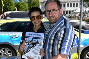 policjanta z plakatem dotyczacym bezpieczeńsdtwa nad wodą