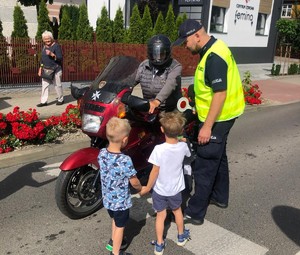 Przedszkolaki i policjant zatrzymuja kierowcę motocykla