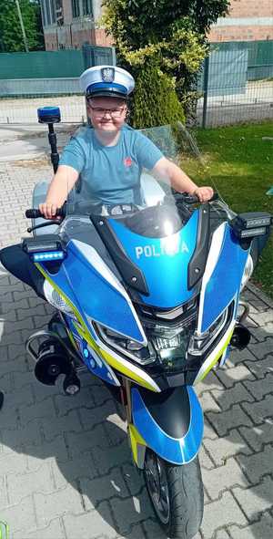chłopiec w policyjnej czapce na motocyklu policyjnym