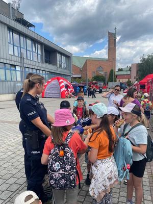 dzieci biorące udział w wyjeździe w towarzystwie policjnatów zgromadzone na placu, na którym zorganizowane zostały atrakcje