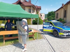 chłopiec mierzy kask, kamizelkę i tarczę służbową