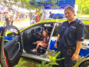 umundurowana policjantka i dziewczynka siedząca w radiowozie