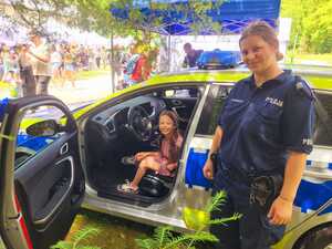 umundurowana policjantka i dziewczynka siedząca w radiowozie