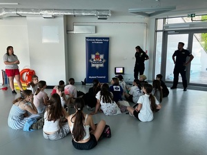 Policjant wspólnie ze strażniczką miejską przeprowadza wyklad dla uczniow