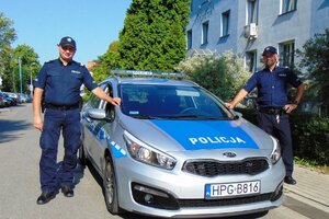 policjanci Smółka i Korczyk stojący przy radiowozie