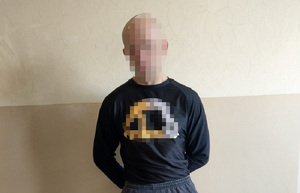 zatrzymany w czarnej bluzie w kajdankach założonych na ręce trzymane z tyłu