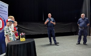 Dzielnicowi z dziećmi na scenie podczas prelekcji