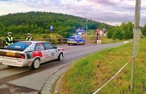 Pojazd wyścigowy na tle policjantów