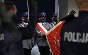 Ślubujący policjanci na drugim planie sztandar
