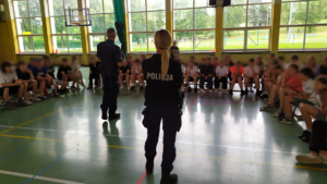 Policjanci oraz uczestnicy półkolonii biorący udział w prelekcji