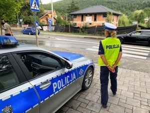 policjant stoi przy radiowozie