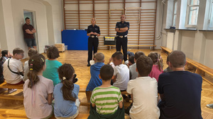 policjanci omawiają z dziećmi zasady bezpieczeństwa podczas wakacji