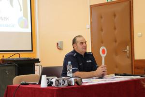 dzielnicowy prezentuje tarczę do zatrzymywania pojazdów