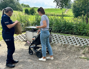 policjantka rozmawia z kobietą z dzieckiem