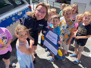 Policjantka pozująca do zdjęcia z przedszkolakami
