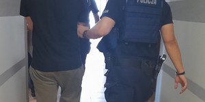 KPP Oświęcim. Zatrzymany obok umundurowany policjant.