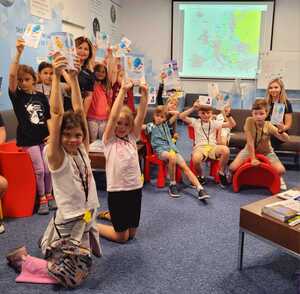 dzieci trzymające kartki z odciskami linii papilarnych