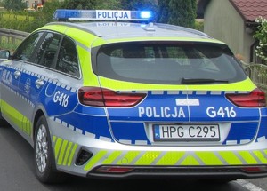 radiowóz z włączonymi sygnałami na ulicy