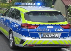 radiowóz z włączonymi sygnałami na ulicy