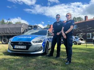 policjanci stojący przy radiowozie