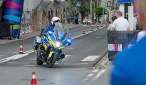 Policjant na motocyklu służbowym w trakcie przejazdu z zawodnikami