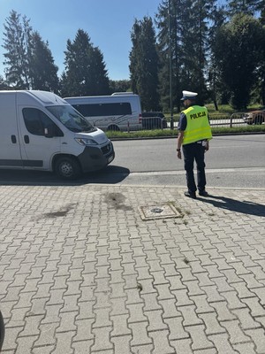 Policjant obok białego busa