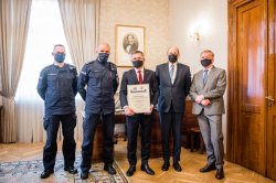 Komendant wojewódzki policji w Krakowie przekazuje certyfikat rektorowi uczelni
