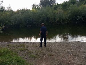 Umundurowany policjant przy przy akwenie wodnym