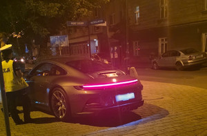 policjant stojący przy samochodzie w trakcie kontroli drogowej w porze nocnej