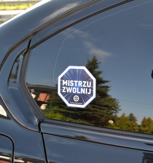Naklejka zwolnij mistrzu przyklejona na szybe poczna pojazdu
