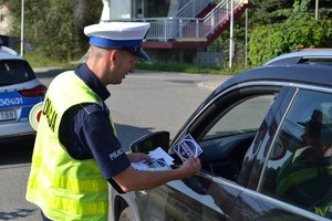 Policjantr przekazujący materiały profilaktyczne