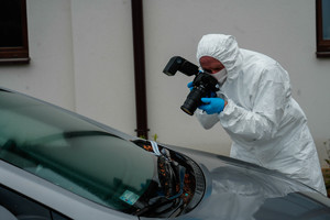 technik kryminalistyki wykonuje zdjęcie