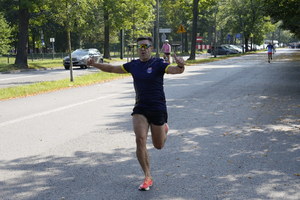 biegnący mężczyzna trzyma ręce w górę w zwycięskim geście