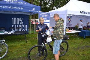 Policjantka wręcza rowerzyście ulotkę
