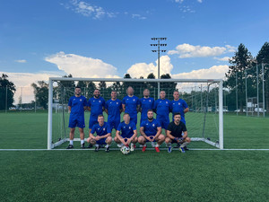 Drużyna piłkarska Komendy Powiatowej w Krakowie na boisku przy bramce.