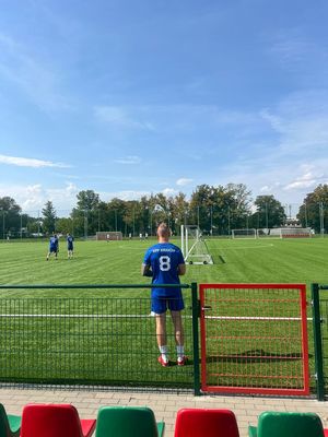 Mężczyźni w strojach sportowych na boisku.