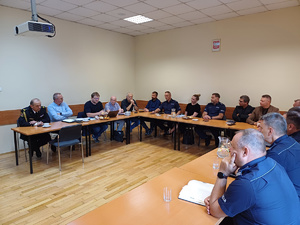 Przedstawiciele Urzędu Miasta Krakowa oraz policjanci siedzący przy stołach podczas spotkania.