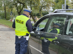 umundurowany policjant pokazuje kierującemu pomiar prędkości