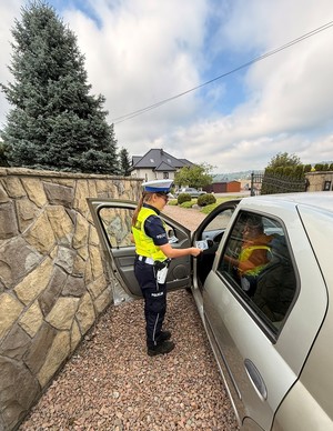 Policjantka wręcza kierowcy naklejkę promującą akcję