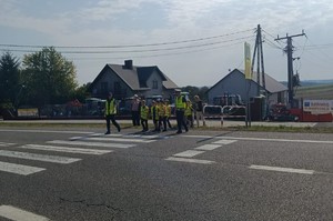 Policjanci przeprowadzają dzieci przez przejści dla pieszych.