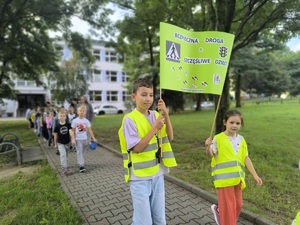 Dzieci niosą transparnt.