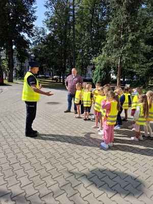 Policjant mówiący dodzieci na zewnątrz dzieci stoja w grupce