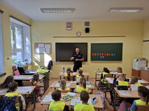 Policjant w sali szkolenj mówiacy dod zieci
