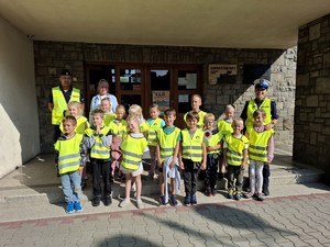 Zdjęcie grupowe dwójkipolicvjantów zdziecmi przedwejsciem do szkoły