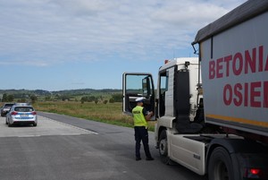 Policjant kontrolujący samochód ciężarowy